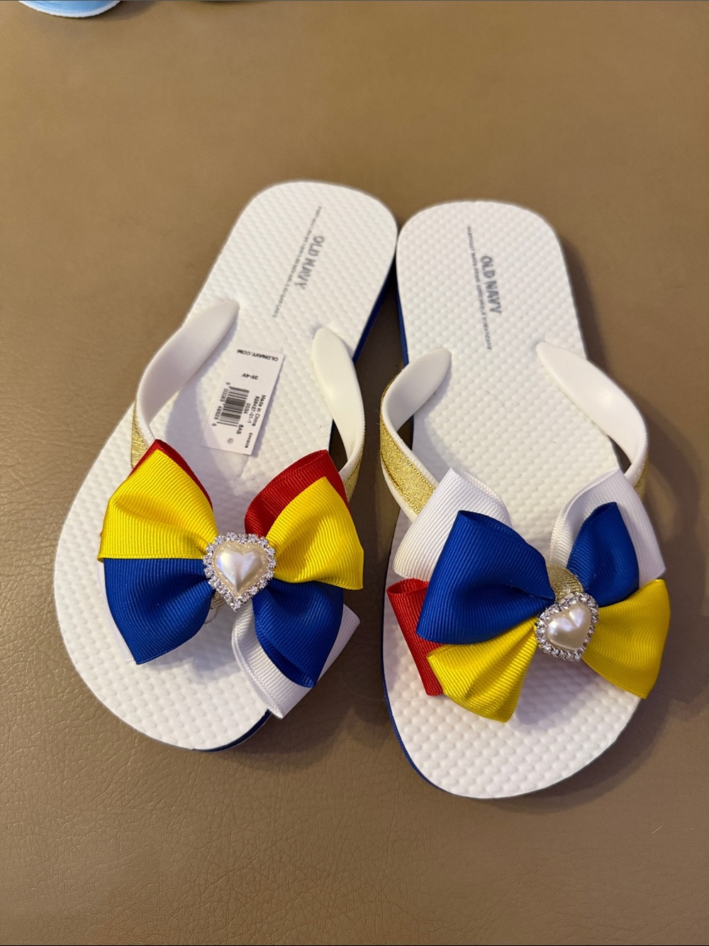 Old Navy White Flip Flop Sandals with Red, Blue & Yellow Bow Accents